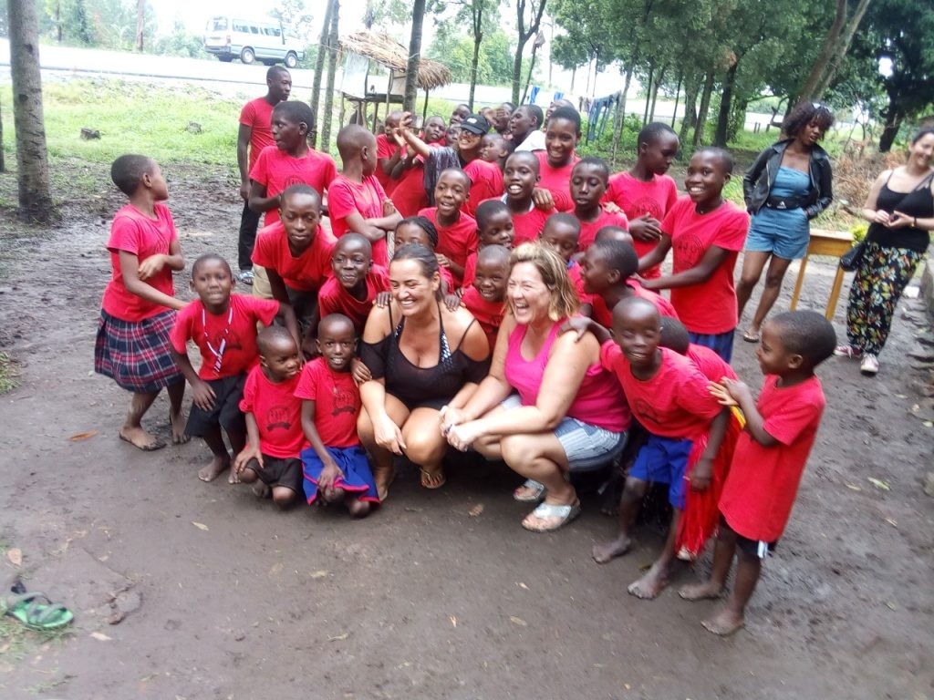 Visitors share a moment with orphans at Kichwamba Orphans Development Centre, Queen Elizabeth National Park