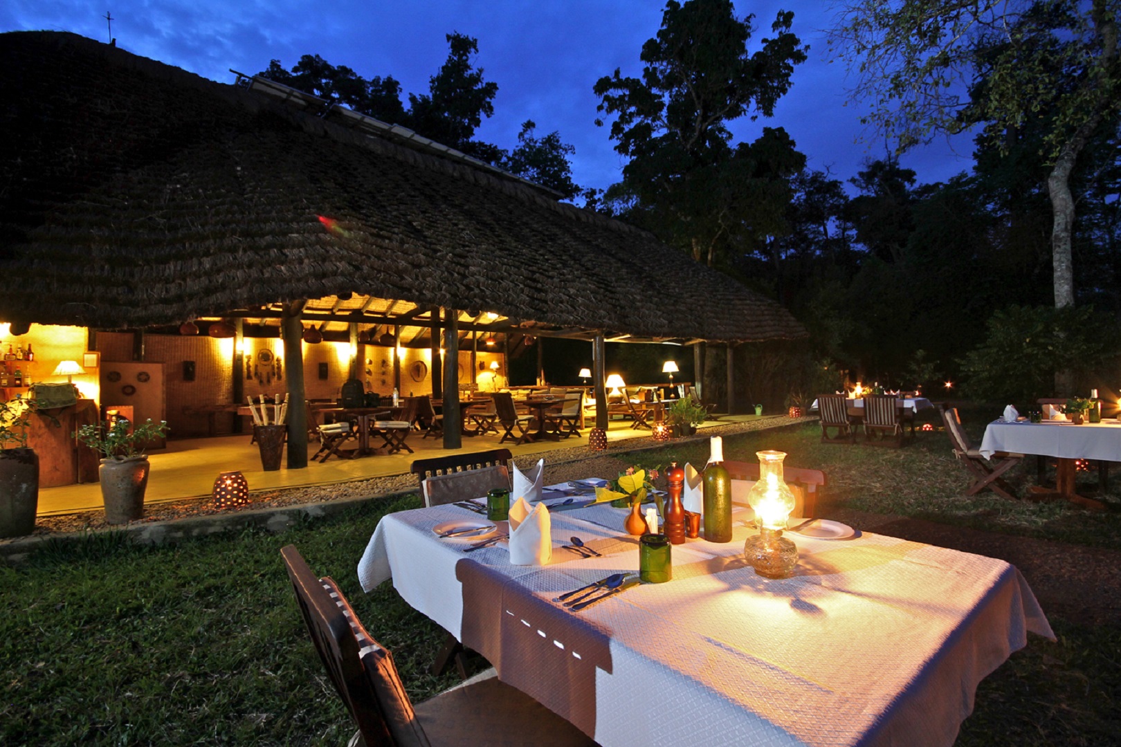 An evening open-air dining setting at Ishasha Wilderness Camp, Queen Elizabeth National Park